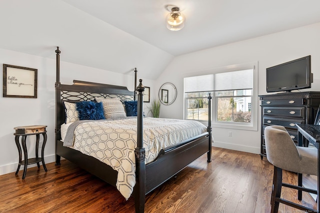 bedroom with vaulted ceiling, wood finished floors, and baseboards