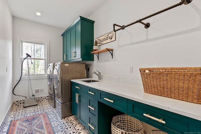 laundry room featuring visible vents, washer and clothes dryer, light tile patterned flooring, cabinet space, and a sink