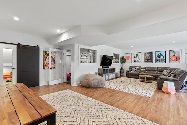 living area featuring recessed lighting, a barn door, baseboards, and wood finished floors