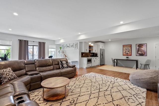 living area with recessed lighting, light wood-type flooring, and baseboards