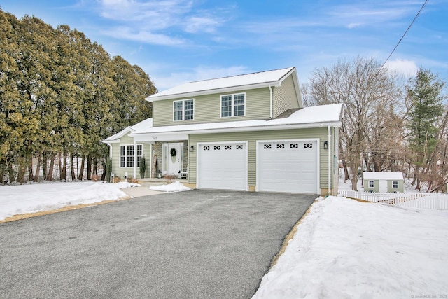 traditional-style home with a garage, driveway, and fence