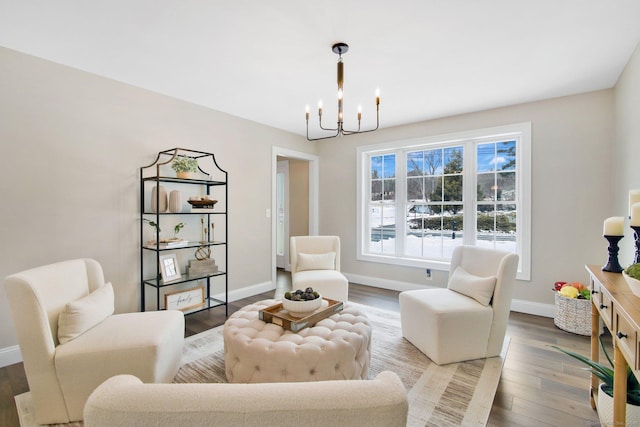 sitting room featuring a chandelier, wood finished floors, and baseboards