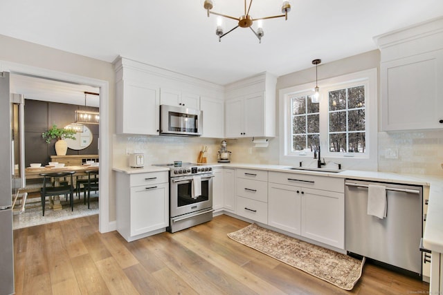 kitchen featuring stainless steel appliances, light countertops, and white cabinetry