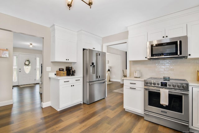 kitchen with white cabinets, decorative backsplash, stainless steel appliances, and light countertops