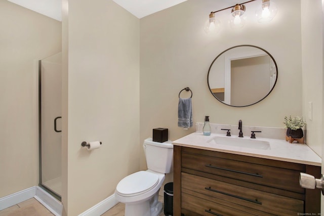 full bath featuring toilet, a shower stall, vanity, and baseboards