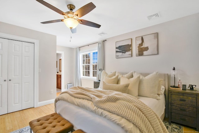 bedroom featuring a ceiling fan, a closet, visible vents, and wood finished floors