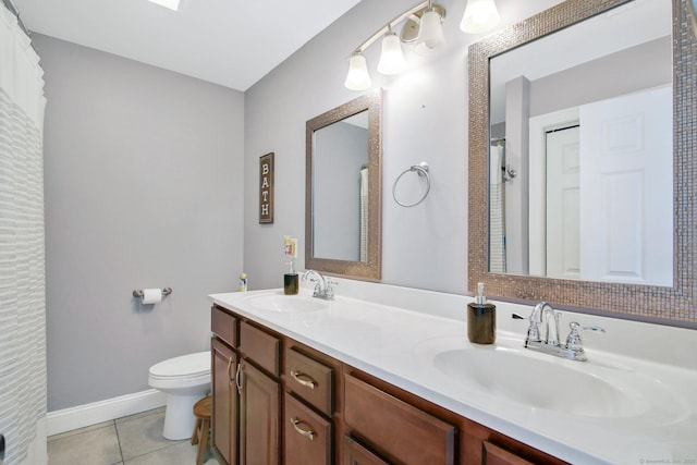 full bath featuring double vanity, a sink, toilet, and tile patterned floors