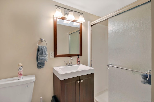 bathroom with a shower stall, toilet, and vanity