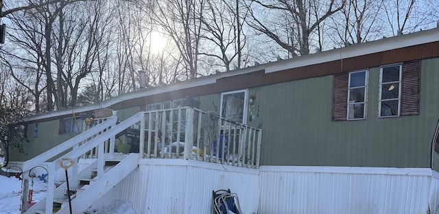 snow covered property with stairway