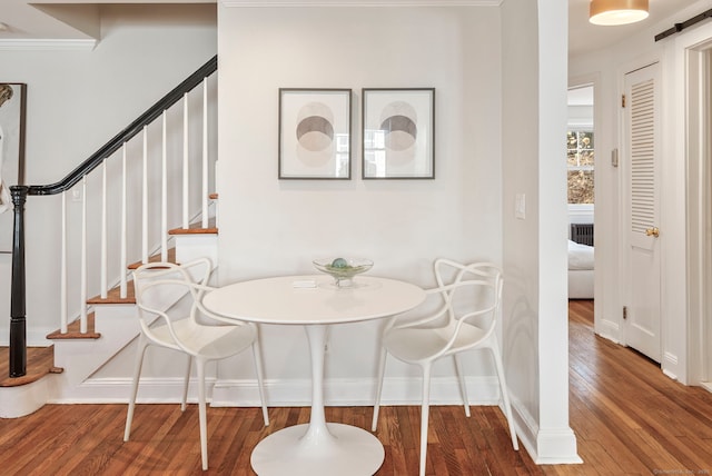 dining area featuring baseboards, stairway, and hardwood / wood-style floors