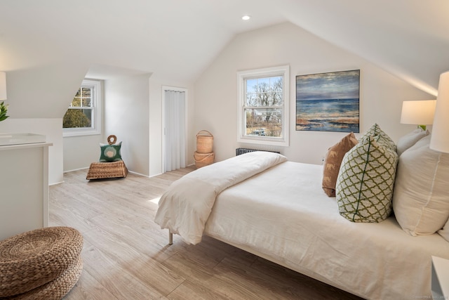 bedroom with lofted ceiling, multiple windows, recessed lighting, and wood finished floors