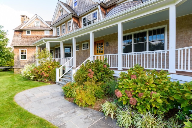 doorway to property featuring a yard and a porch