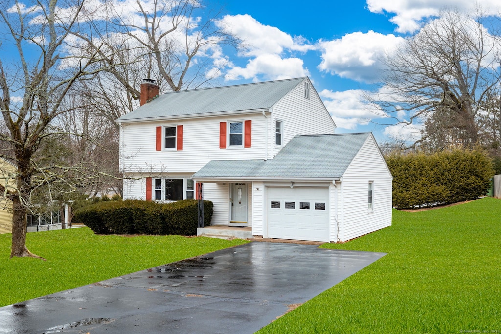 197 Highland St, Manchester, CT 06040 - view of front of house with driveway, a chimney, a front lawn, and a garage