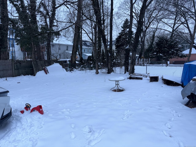 yard layered in snow featuring fence