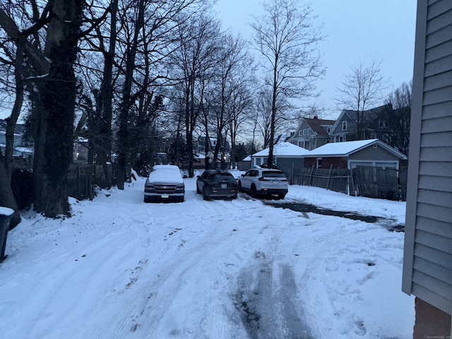 yard covered in snow featuring a residential view and fence