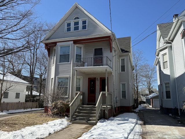 view of front of home featuring a balcony, a porch, and an outbuilding