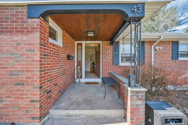 view of exterior entry featuring brick siding