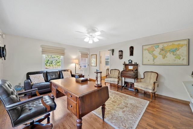 office space featuring a ceiling fan, wood finished floors, and baseboards