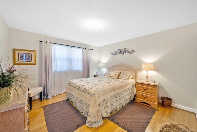 bedroom featuring baseboards and light wood-style floors