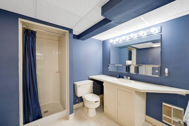 full bath with tile patterned floors, toilet, a stall shower, a drop ceiling, and vanity