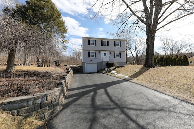 colonial-style house featuring a garage and driveway