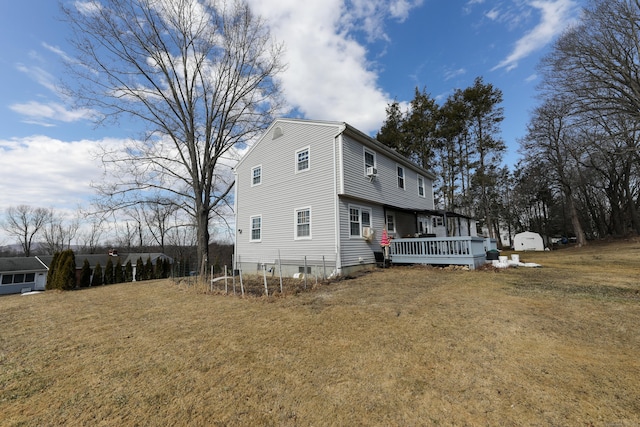 back of house featuring a deck and a lawn