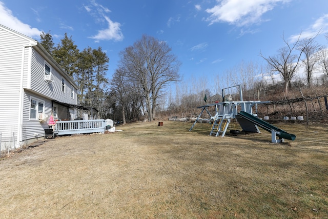 view of yard with a deck and a playground