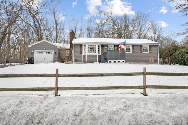 view of front of property featuring a chimney, fence, an outdoor structure, and a garage