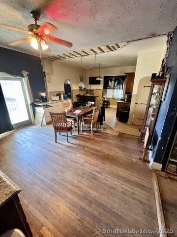 dining room featuring ceiling fan, wood-type flooring, and a textured ceiling