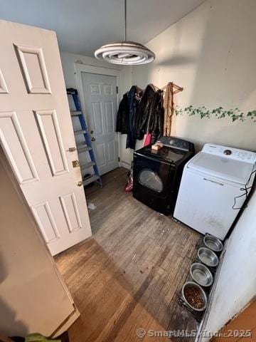 clothes washing area with separate washer and dryer and wood-type flooring