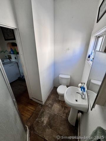 bathroom with washer / clothes dryer and toilet