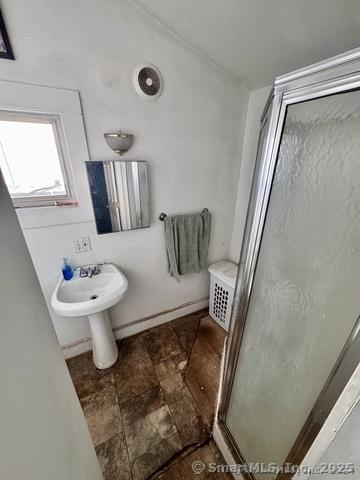 bathroom featuring sink and a shower with door