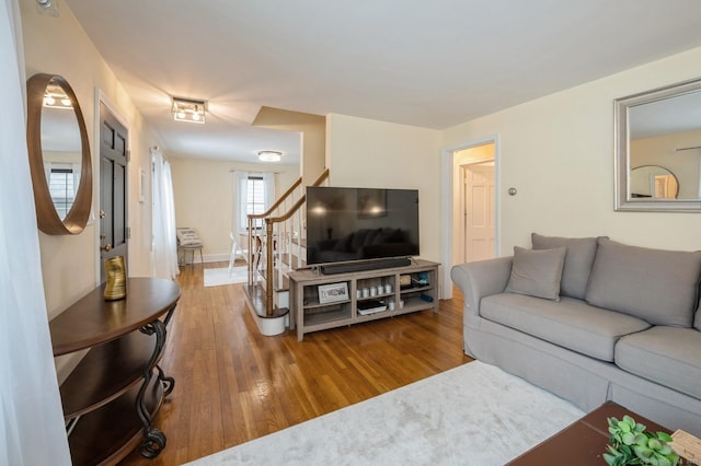 living room with baseboards, stairway, and wood finished floors