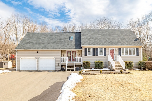 view of front of home with covered porch, aphalt driveway, a shingled roof, and a garage