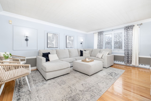 living room featuring a baseboard heating unit, ornamental molding, and hardwood / wood-style flooring