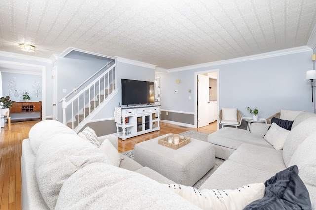 living area featuring ornamental molding, stairway, baseboards, and wood finished floors