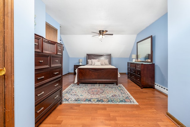 bedroom featuring baseboards, baseboard heating, and light wood-style floors