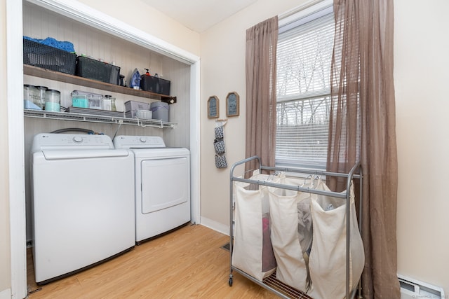 laundry room featuring a baseboard radiator, washing machine and dryer, light wood-style flooring, laundry area, and baseboards