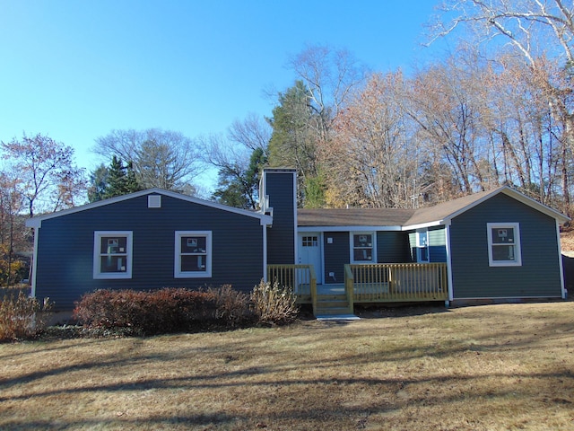 view of front facade with a front lawn and a wooden deck