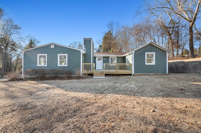 rear view of property with a chimney and a wooden deck