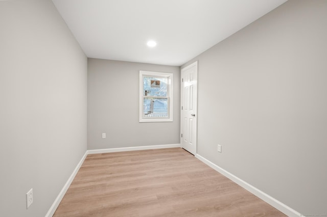 spare room featuring light wood finished floors and baseboards