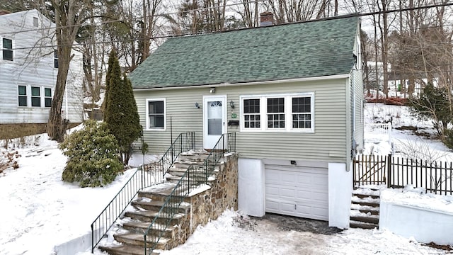 view of front of home with a garage, a chimney, and roof with shingles