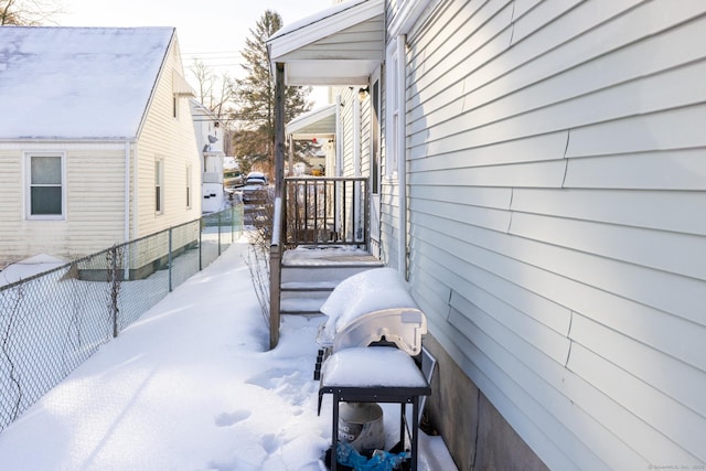 snow covered back of property with grilling area