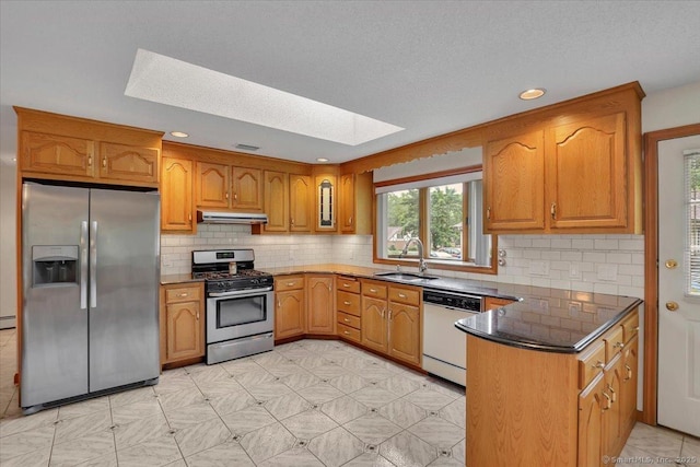 101 Langford Ln, East Hartford, CT 06118 - kitchen featuring stainless steel appliances, under cabinet range hood, a skylight, a sink, and brown cabinets