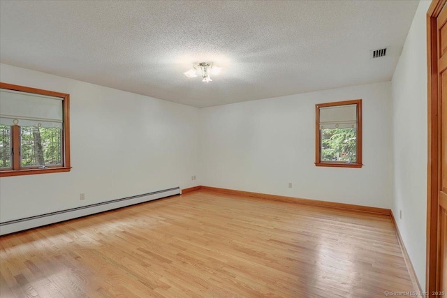 101 Langford Ln, East Hartford, CT 06118 - empty room featuring a baseboard heating unit, plenty of natural light, light wood-style floors, a textured ceiling, and baseboards