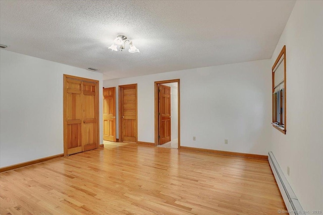 101 Langford Ln, East Hartford, CT 06118 - empty room featuring a baseboard radiator, light wood-style flooring, a textured ceiling, and baseboards