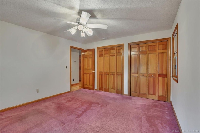 101 Langford Ln, East Hartford, CT 06118 - unfurnished bedroom featuring multiple closets, carpet floors, baseboards, a ceiling fan, and a textured ceiling