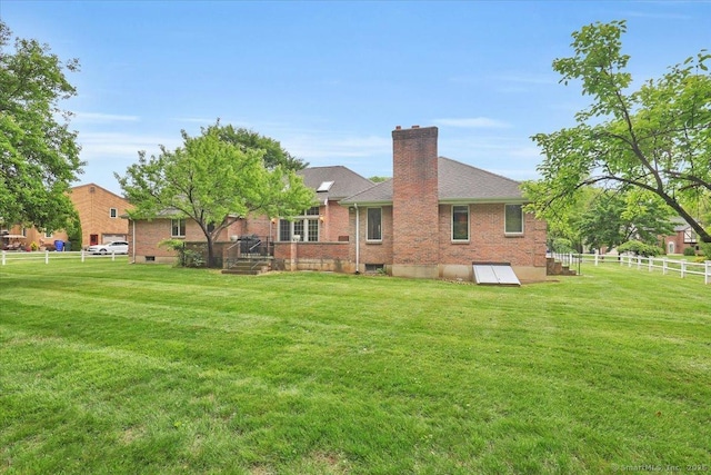 101 Langford Ln, East Hartford, CT 06118 - back of house featuring a chimney, brick siding, and roof with shingles
