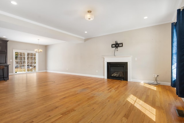 unfurnished living room featuring ornamental molding, a glass covered fireplace, light wood-style flooring, and baseboards