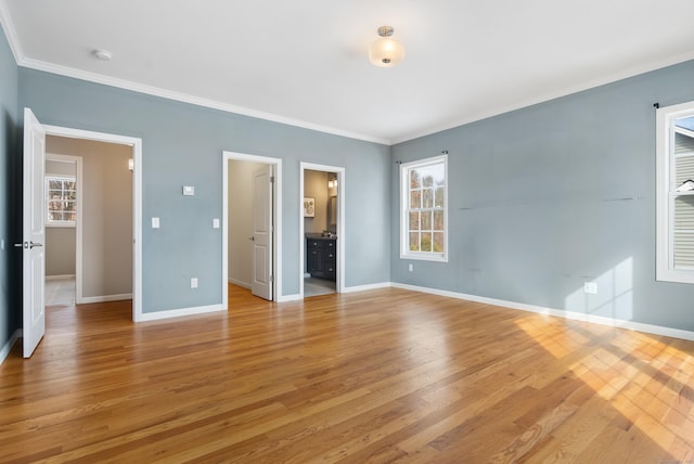 unfurnished bedroom featuring light wood-type flooring, multiple windows, baseboards, and crown molding